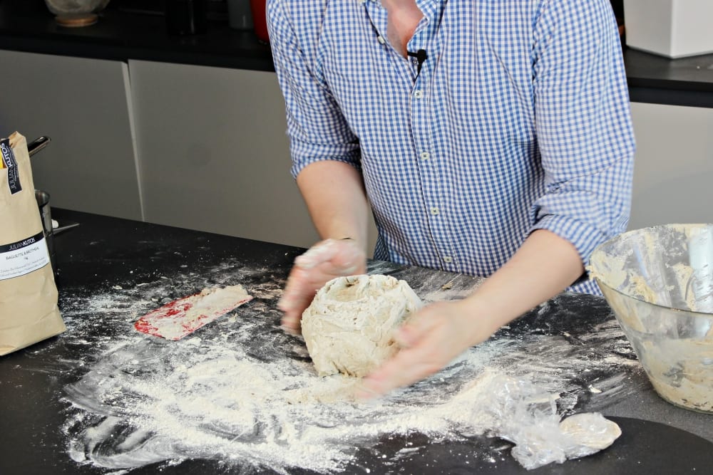 Koch Julian Kutos knetet Brotteig für sein Bauernbrot – Wie backe ich ein Bauernbrot? –Entdeckermagazin Miomente