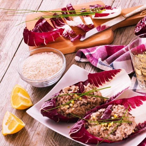 Radicchio-Risotto mit Walnüssen und fluffigem Orangenschaum, angerichtet auf einem weißen Teller