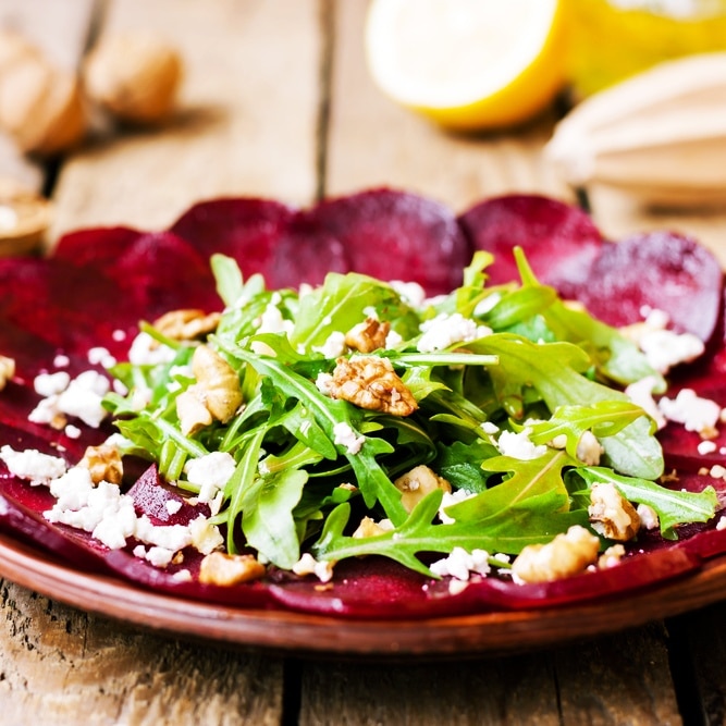 Kalte Vorspeise: Dünne Rote-Bete-Scheiben mit Ziegenkäse, Walnüssen und frischen Kräutern