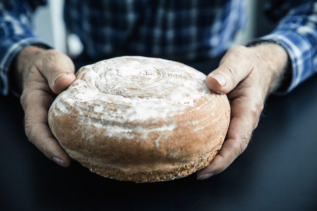 Backkurs Augsburg – Mann hält Brot in Händen