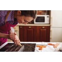 Pralinenkurs Augsburg – Frau füllt Schokolade in Pralinenform