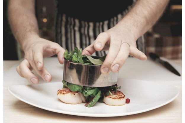 Teambuilding in Essen - Mann richtet mit Servierring an