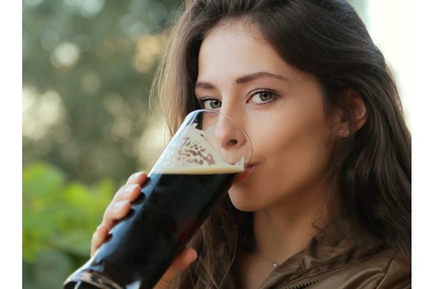 Braukurs München - Junge Frau genießt dunkles Weißbier