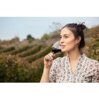 Weinprobe München – junge Winzerin mit Rotwein im Weinberg