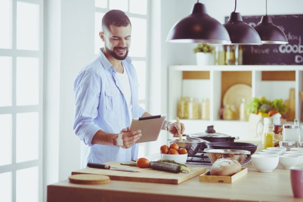 Online Kochkurs –  Mann kocht zuhause mit Tablet