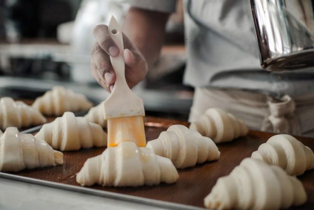 Backkurs in München: Croissants vor dem Backen bestreichen